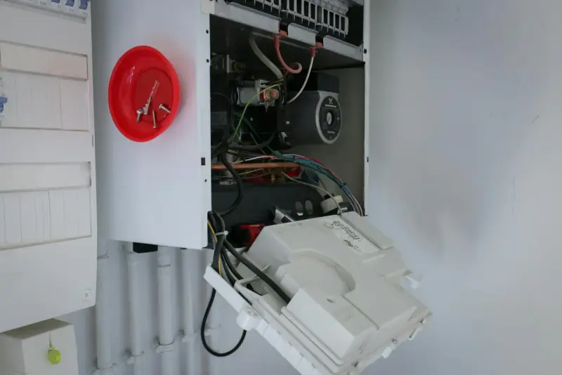 Ouvert pour l'entretien chaudière gaz obligatoire, on voit le circuit électrique et la pompe.
